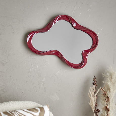 Violeta Resin Wall Mirror in red, 47x62cm, with a glossy wavy resin frame forming rounded lobes, mounted on a light grey textured wall.