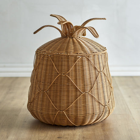 Anann Pineapple Basket with Lid in beige polyrattan, a rounded floor basket with woven leaf-topped lid, shown on a wooden floor against a plain light background.