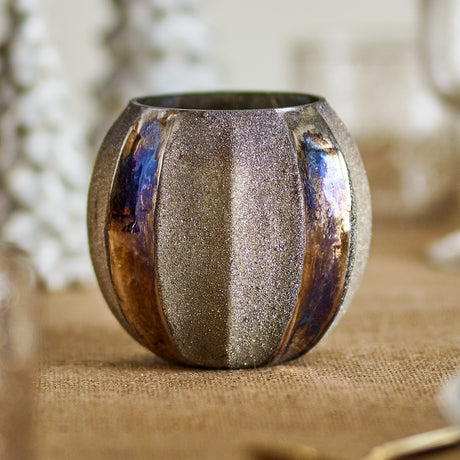Felecia Striped Glass Christmas Tealight Holder in gold, round recycled glass design with alternating textured and iridescent oxidised vertical panels, shown on a table setting.