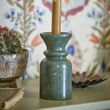 Sicilia Marble Candle Holder 15.5cm in green with polished finish, flared cup and rounded collar, holding a taper candle on a living-room shelf.