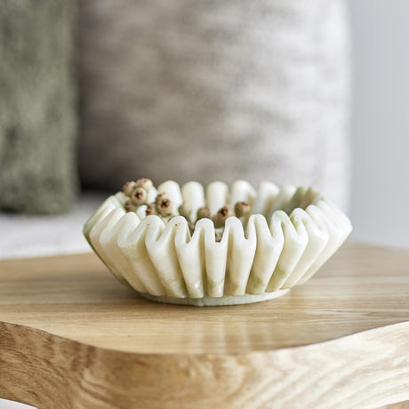 Harmonia Fluted Marble Bowl 17.5cm in white with deep pleated flutes and a wavy rim, holding dried seed pods on a wooden table.