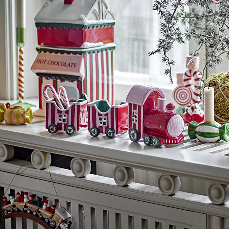 Gloria Striped Ceramic Christmas Decoration in red, a three-piece ceramic train with chimneyed locomotive and two open wagons, shown on a mantel with festive decor.