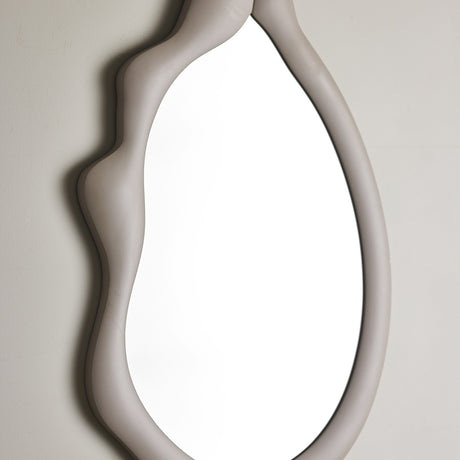 Aika Wall Mirror 60x94cm in beige, close-up of the wavy MDF frame with soft curves and lobed top edge around a pebble-shaped mirror glass, against a plain light background.