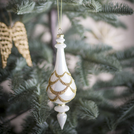 Hisar glass Christmas tree decoration, 18.5cm white finial-shaped bauble with gold glitter scallop pattern, hanging from a pine branch with a gold cord.
