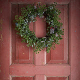 Cedar artificial Christmas wreath, 50cm, green faux sprigs with pinecones and frosted tips, hung on a weathered red panelled door.