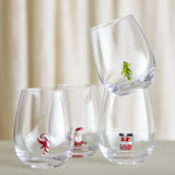 Misa Christmas Tumblers Set of 4 in clear glass, each stemless tumbler featuring a small figure inside—candy cane, waving Santa, Santa's boots in a chimney, or a Christmas tree.