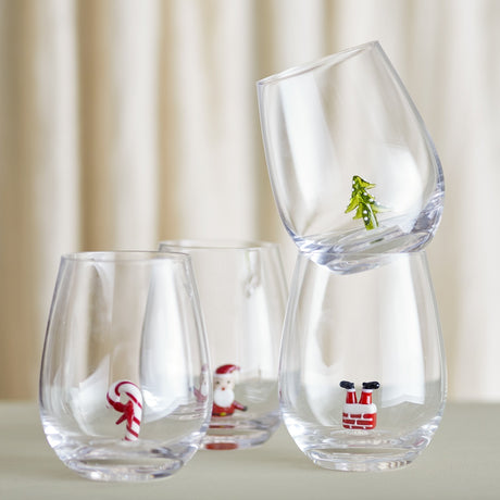 Misa Christmas Tumblers Set of 4 in clear glass, each stemless tumbler featuring a small figure inside—candy cane, waving Santa, Santa's boots in a chimney, or a Christmas tree.