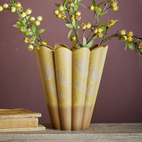 Penn Speckled Stoneware Vase 29cm in yellow with fluted, scalloped rim and speckled glaze over an earthy base, holding berry branches on a wooden surface against a mauve wall.