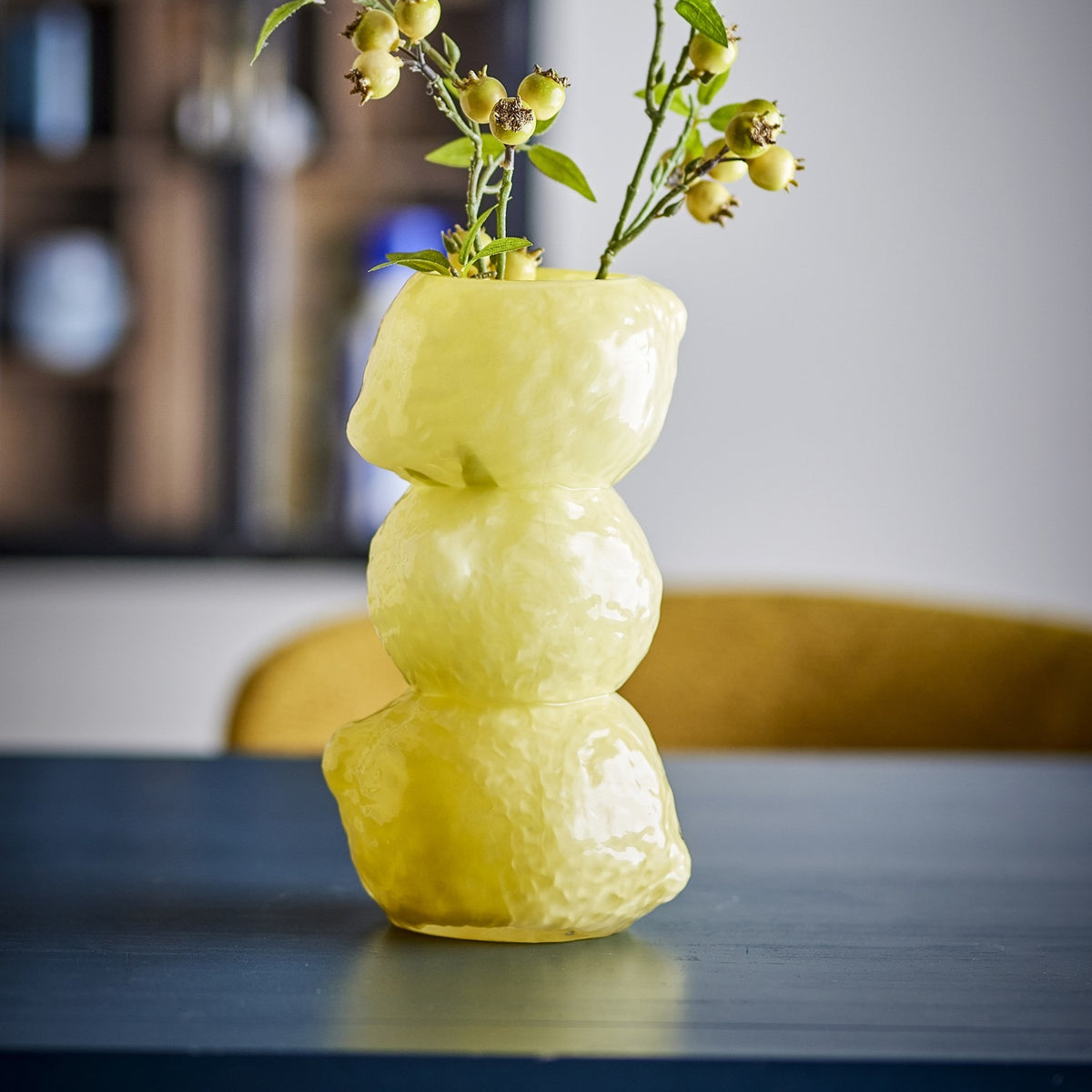 Limone Glass Vase 27cm in Yellow, with three stacked dimpled glass forms and a glossy finish, holding berry stems on a dark tabletop.