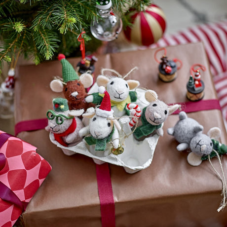 Peo Wool Christmas Tree Decorations, set of six felt mice in multicoloured festive outfits with hats, scarves and a bell, displayed in an egg carton beside gift-wrapped boxes.
