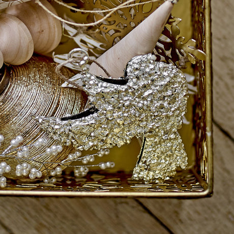 Sarika Iron Christmas Tree Decoration in gold, bird-shaped with lifted wings and fanned tail, textured crusted metal finish, with hanging loop, displayed in a decorative tray.