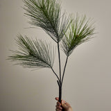 Pine Artificial Christmas Stem, 114cm, held by hand to show three branching green needle sprays on a slim bare stem against a plain neutral background.
