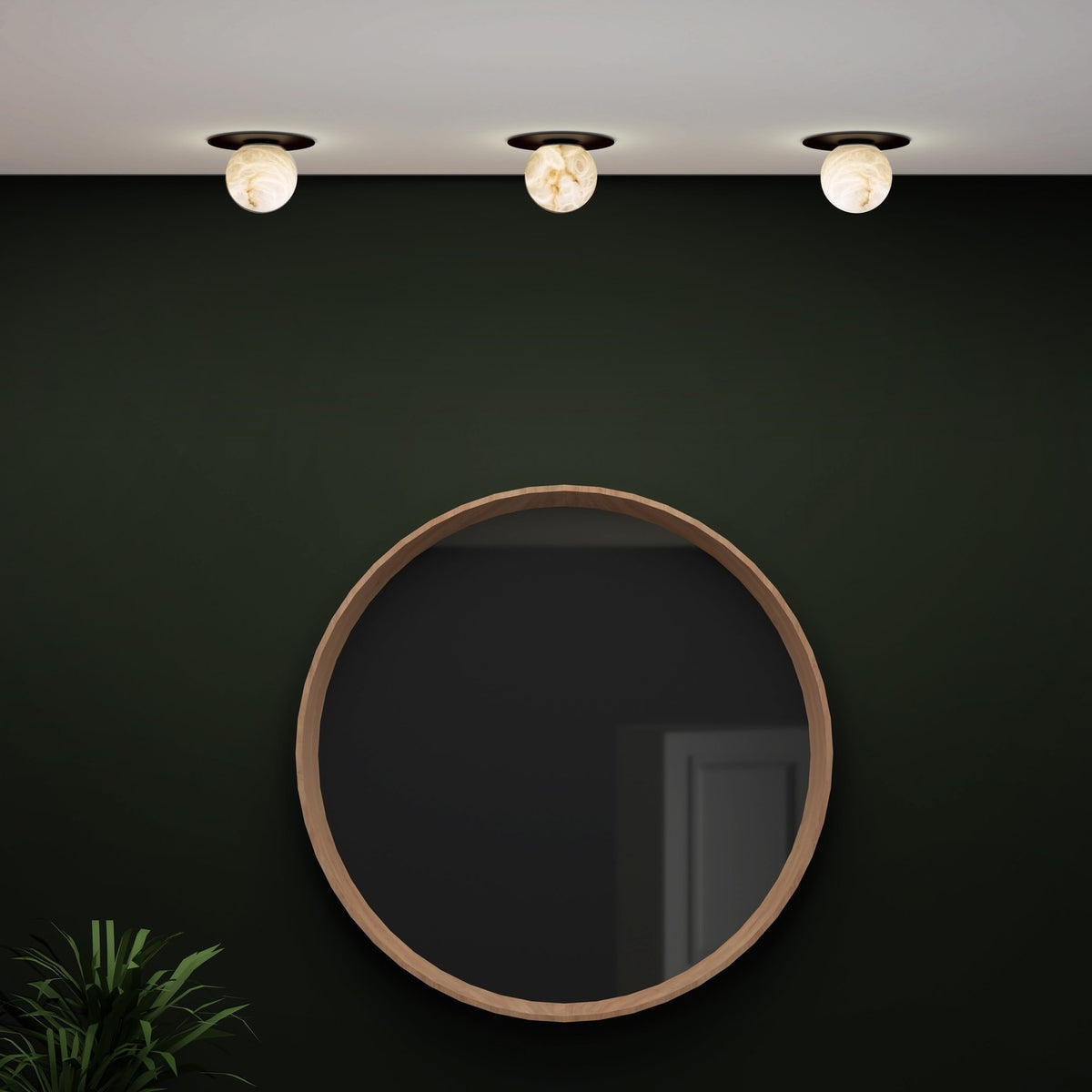 Halvessa LED Alabaster Downlight in black, three round ceiling fittings with glowing alabaster globes showing grey and brown veining, installed above a round wood-framed mirror on a dark green wall.