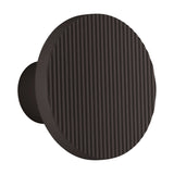 Arid A/01 round LED wall light in Textured Black aluminium, showing a fluted disc face on a short stem, set against a plain white background.