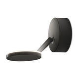 Bella Direct Aluminium LED Wall & Ceiling Light in matte black, featuring a round wall plate, slim angled arm and flat disc head with a soft glowing rim, shown on a plain white background.