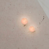 Two Rock LED alabaster drum flush wall lights glowing warm white on a textured wall, black base, IP44 rated.