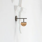 Roi single arm wall light with black backplate and straight arm holding a ribbed fumé glass dome shade, shown on a plain white wall.