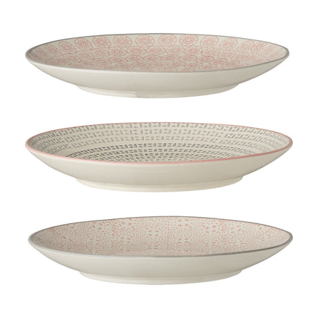 Cécile ceramic side plates in three assorted patterned designs, cream with pink and grey motifs, shown stacked on a plain white background.