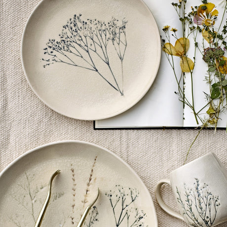 Bea Crackle Stoneware Side Plate in cream with botanical sprig motif and hairline crackle glaze, styled with a matching cup and pressed flowers on linen.