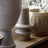 Isold Stoneware Vase 22cm in beige with a slender neck and two stacked flared rings on a short foot, matt ceramic finish, shown among other vases.