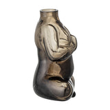 Elze Glass Vase 12.5cm in Brown, a seated-figure shaped glass vase with crossed legs and hands at the chest, translucent brown finish darkest at the base, shown on a plain white background.