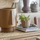 Guxim Stoneware Plant Pot in brown with face-like details, tapering nose, ear shapes and ribbed foot, shown on a rattan table beside books and a small succulent planter.