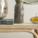 Gerde Stoneware Vase 21cm in brown with pressed sunburst pattern, zigzag bands and dotted ring, shown on a rattan table beside books and glass decor.