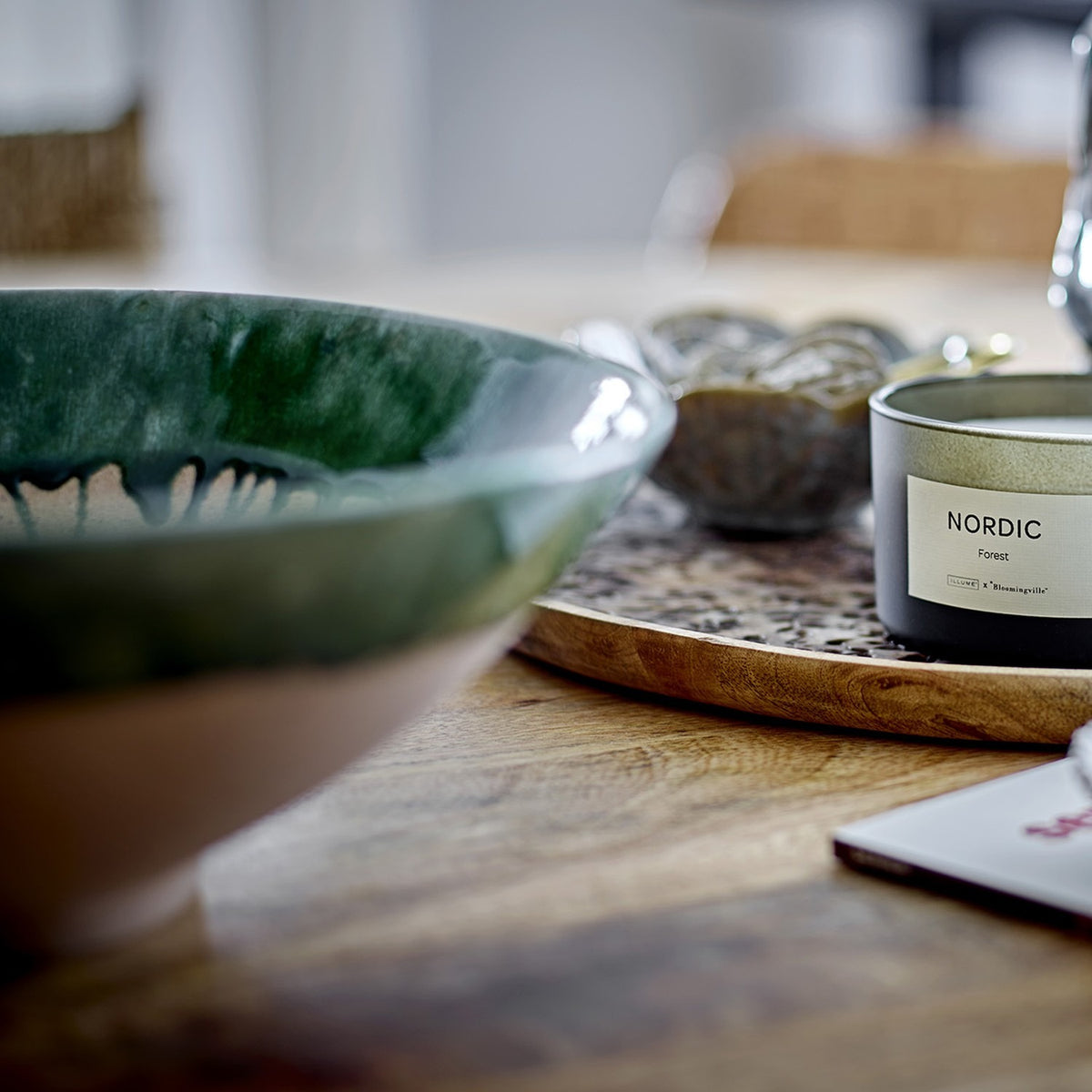 Moez Stoneware Bowl 30cm in green, wide ceramic bowl with glossy green rim glaze and speckled interior, shown on a wooden table beside a Nordic candle.