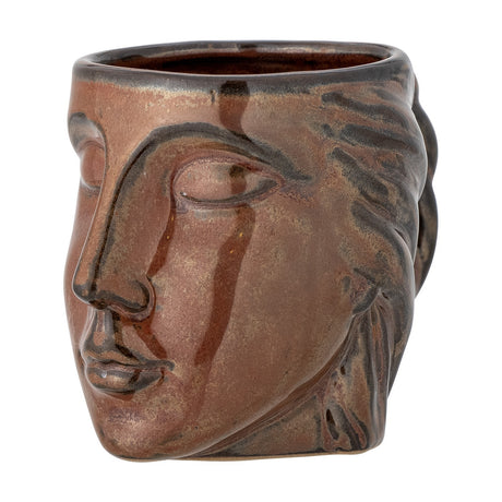 Reeha Stoneware Mug 310ml in brown, sculpted as a face with closed eyes, nose and lips, hair swept back into a plaited handle, on a plain white background.