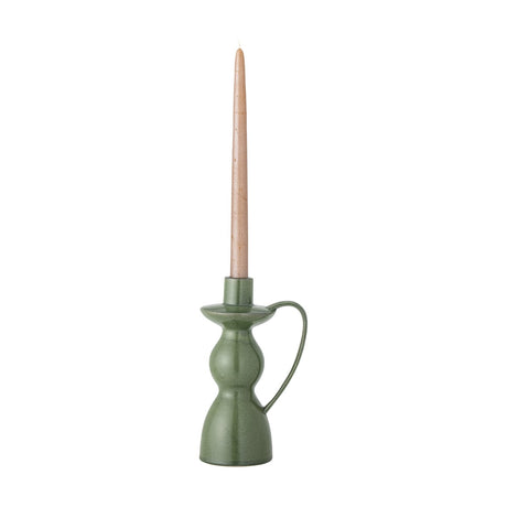 Green Fija stoneware candlestick, 22.5cm, chamberstick style with wide rim, bulging body, bell base and tall loop handle, shown holding a taper candle on white background.