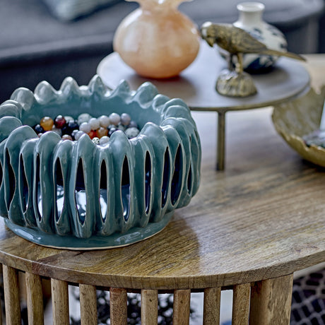 Mavel Stoneware Plant Pot in green, a low wide ceramic bowl with vertical slits and a scalloped rim, shown holding beads on a wooden table.