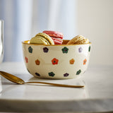 Addy Stoneware Bowl 12cm in cream with hand-painted multicoloured flowers and a yellow-glazed rim, filled with macarons beside a gold spoon on a marble surface.