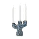 Tahoka Stoneware Candle Holder in blue with a textured, tree-like branching base holding three white taper candles at varying heights, shown on a plain white background.