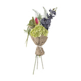 Poetry Artificial Bouquet in Green, featuring large hydrangea heads, dark veined orchid sprays, an anthurium, ferns and trailing foliage, wrapped in paper with ribbon tie, on a plain white background.