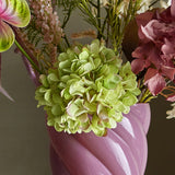 Close-up of the Hydrangea Artificial Stem 36cm in green, showing a full rounded flowerhead with ruffled petals, arranged in a pink vase among other faux florals.
