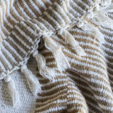 Close-up of the Isnel Brown Striped Cotton Throw showing ribbed woven stripes in brown and white with a knotted fringe edge.