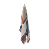 Clarita Cotton Throw in Multi, a woven geometric pattern of orange, navy and beige blocks with fringed edges, hanging against a plain white background.