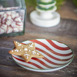 Jolly Striped Stoneware Christmas Plate in multicoloured red and white with green rim, 16cm size, shown holding a star-shaped iced biscuit on a wooden table.