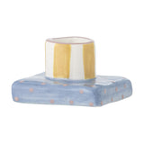 Tacana Striped Stoneware Candle Holder in multicoloured ceramic, featuring a round yellow and white striped cup on a square blue base with pink dots, set against a white background.