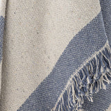 Close-up of the Ethan Cotton Throw in blue, showing a woven two-tone diagonal pattern in beige and blue with a fringed edge detail.