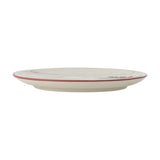 Side view of a cream stoneware Christmas side plate from the Jovida set of 4, showing its thin rim edged in red and embossed detailing, on a plain white background.