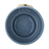 Top-down view of a stoneware kids' cup from the Party Dotted Dinner Set, showing a blue glazed interior and raised dog face detail on the outer rim, plain white background.