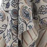 Close-up of the Paisley Floral Cotton Throw in multi, showing navy and rust paisley and floral print on draped fabric with a striped reverse side visible.