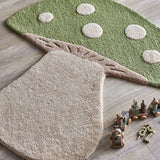 Mushroom Wool Rug 90x85cm in green with raised cream spots, gill detailing and a cream stem, shown on a wooden floor beside wooden toys.