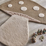 Mushroom Wool Rug 90x85cm in brown, shaped like a mushroom with a spotted cap, carved gill texture, and a rounded stem, shown on a wooden floor beside wooden toys.