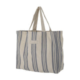 Trina Striped Cotton Shopping Bag in blue, a roomy canvas tote with vertical stripes of varying widths, two carry handles, and a small brand label, shown against a plain white background.
