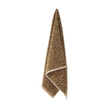 Kaysa Cotton Towel 100x50cm in brown, hanging with a branching coral-like woven pattern in light and dark brown tones, cream edge trim, against a plain white background.
