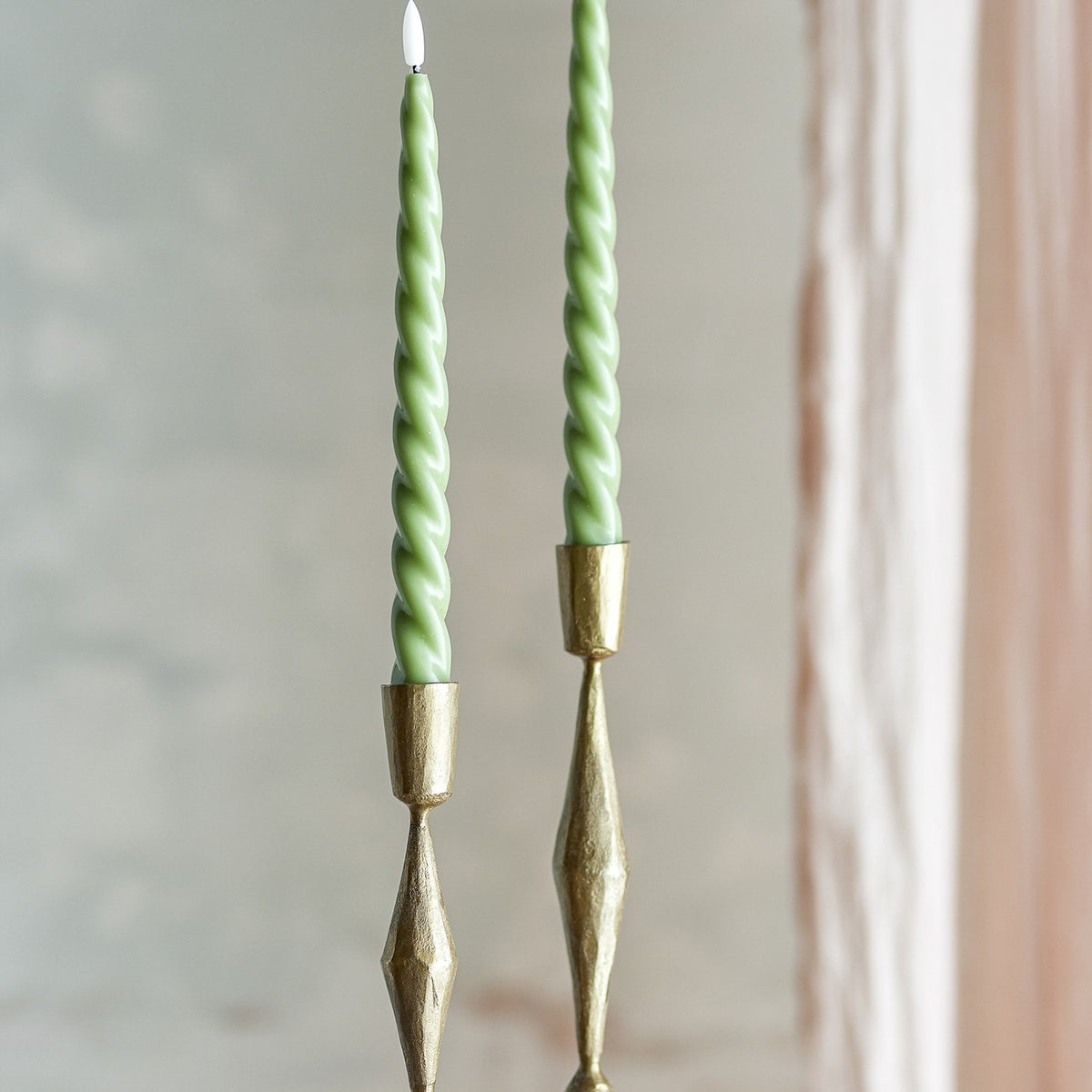 Ponza LED taper candles, pack of 2, green spiral-twist paraffin wax design on brass candlesticks against a neutral background.