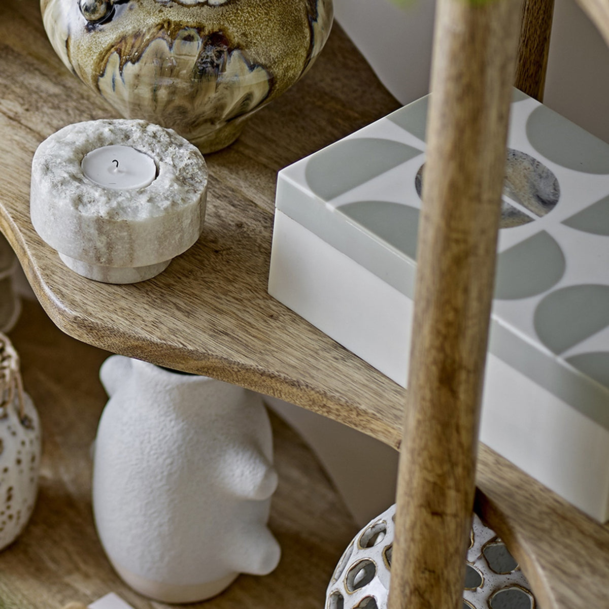 Kabela Resin Storage Box with Lid in grey, featuring a geometric half-circle pattern and centre circle, shown on a wooden shelf among decorative ornaments.