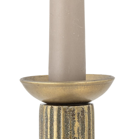 Fargo Iron Candle Cuff in gold, a small round dish-shaped drip tray with a flared hollow, fitted around a taper candle atop a ridged candlestick, on a plain white background.